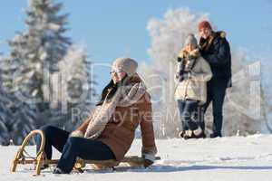 friends enjoy sunny winter day on sledge