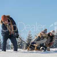 friends having fun on sledge sunny winter