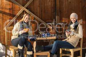 two young women enjoy tea winter cottage