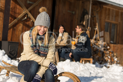 young woman with friends snow winter cottage