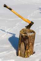 ax stuck in wood log snow winter