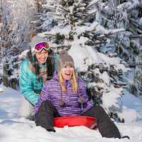 two female friends on bobsleigh winter snow