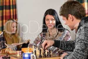 young couple play chess winter cottage countryside