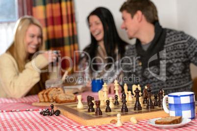 playing chess winter chalet friends laughing