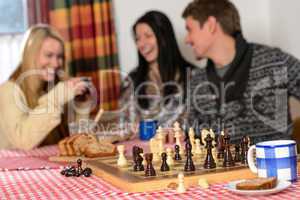 playing chess winter chalet friends laughing