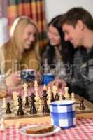 young people play chess winter cottage countryside