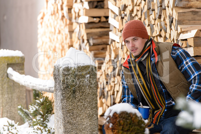 young handsome man posing winter fashion wood