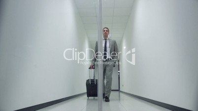 business man walking in corridor of office building with trolley