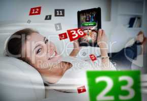 Woman lying on couch and gambling on tablet