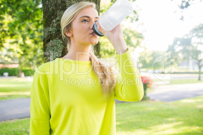 Fit peaceful blonde drinking from sports bottle
