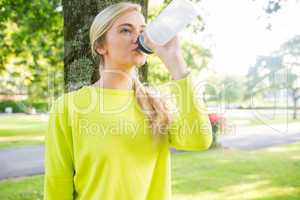 Fit peaceful blonde drinking from sports bottle