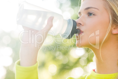 Fit blonde drinking from sports bottle