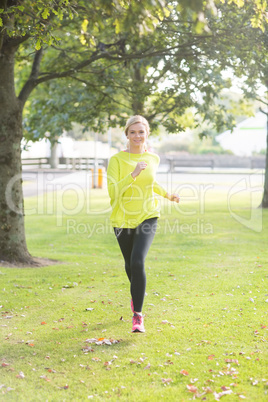 Active smiling blonde jogging towards camera