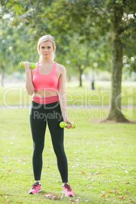 Active beautiful blonde lifting dumbbells