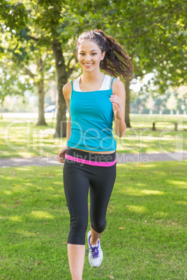 Active smiling brunette jogging