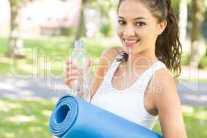 Active content brunette holding exercise mat