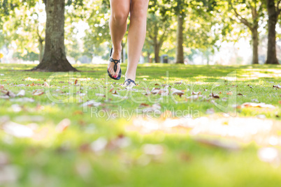 Close up of female feet wearing sandals walking on grass