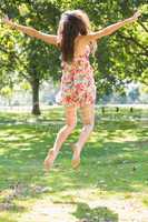 Rear view of beautiful stylish brunette jumping in the air