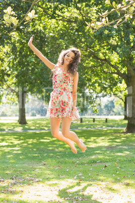 Stylish cheerful brunette jumping in the air