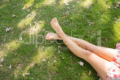 Close up of female crossed legs lying on the grass