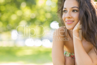 Stylish beautiful brunette sitting under a tree