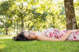 Stylish beautiful brunette lying on a lawn