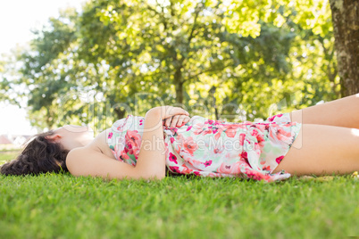 Stylish peaceful brunette lying on a lawn