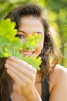 Gorgeous smiling brunette holding a leaf