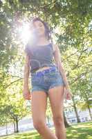 Casual gorgeous brunette standing on grass in sunlight