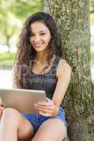 Casual attractive brunette sitting using tablet