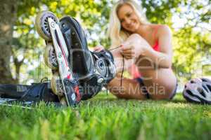 Casual happy blonde putting on roller blades