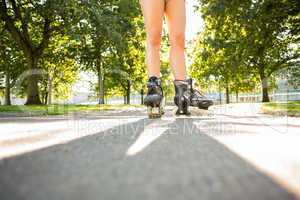 Close up of woman wearing inline skates standing on pathway