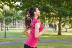 Serious sporty woman jogging in a park