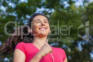 Joyful sporty woman jogging in a park