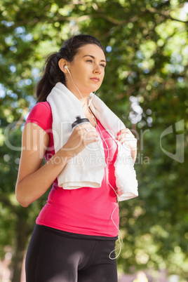 Sporty brunette woman posing while holding a towel