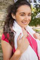 Attractive sporty woman leaning against a tree