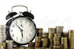 time is money concept: alarm clock and lots of euro coins