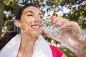 Gorgeous sporty woman drinking water out of a bottle