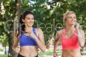Two sporty women jogging in a park