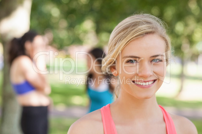 Beautiful blonde sporty woman posing in a park