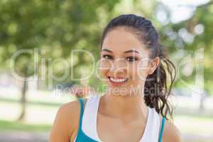 Portrait of cute sporty woman posing in a park