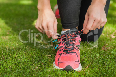 Close up of sporty woman tying her shoelaces