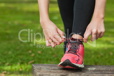 Young woman tying the shoelaces of her running shoes