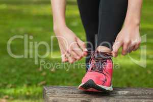 Young woman tying the shoelaces of her running shoes