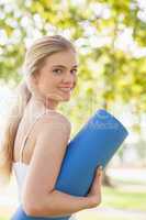 Gorgeous blonde woman posing holding an exercise mat