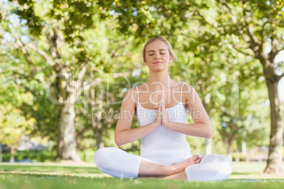 Content peaceful woman meditating sitting on an exercise mat