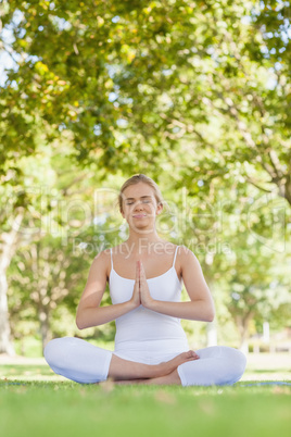 Calm beautiful woman meditating sitting in a park