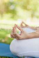 Mid section of young woman meditating sitting on an exercise mat