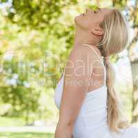 Profile view of blonde young woman doing yoga in a park
