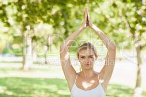 Pretty fit woman doing yoga in a park